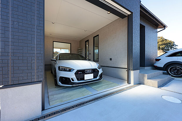 【１号棟】室内から愛車を眺められる、車好き憧れのインナーガレージ。ダウンライトが愛車を美しく照らし出し、天候を気にせず趣味の時間を満喫できます。暮らしと趣味が融合した、贅沢なプライベート空間です。