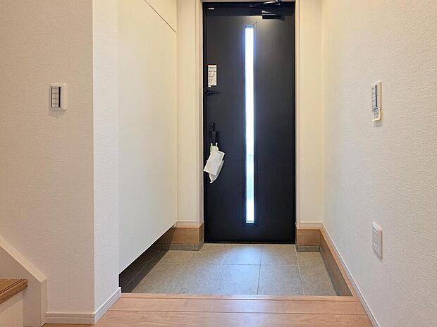 【玄関】玄関には縦スリット窓付きのドアを採用し、外からの光が差し込む明るい空間となっています。シューズボックスも設置されており、すっきりとした玄関まわりを保てます。