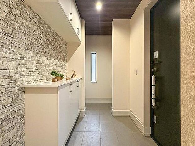 【玄関】デザイン性の高い石目調の壁が印象的な玄関。豊富な収納と明るい空間で、家族を温かく迎え入れ、毎日を快適にスタートできます。