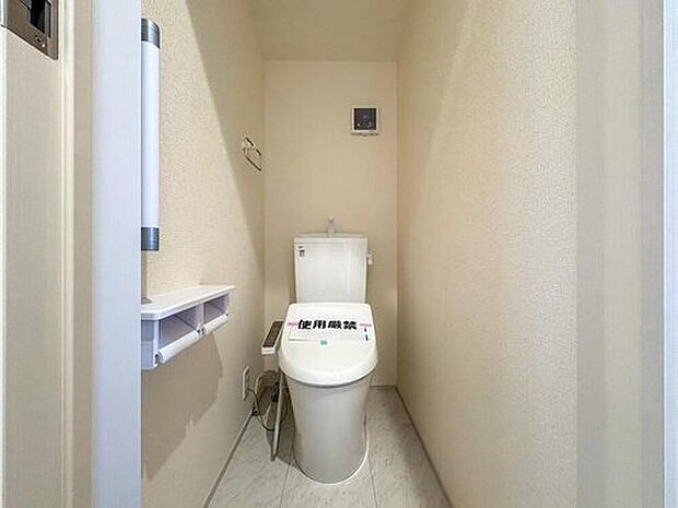 【トイレ】清潔感あふれるシンプルなトイレは、ウォシュレット機能付きで快適な使い心地です。トイレットペーパーホルダー付きの収納棚も備え、家族みんなが気持ちよく使える空間を演出します。