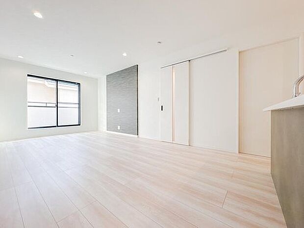 【リビング】白を基調とした、清潔感あふれる明るい広々リビング。柔らかな光が差し込む複層ガラスの窓を採用し、冬暖かく夏涼しい快適な住空間を叶えます。ダウンライトがスッキリとした天井を演出し、開放感を高めます。