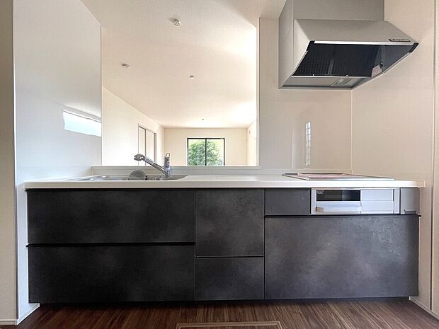 【キッチン 同社施工例写真】キッチンの表面は水はねや汚れからガードするパネルタイプの壁材を採用。目地が少なく、汚れの拭き取りが簡単です。インテリア性に優れた人造大理石製。肌触りがよく、耐久性があり、清掃性にも優れています。IHクッキングヒーターでお手入れラクラク♪