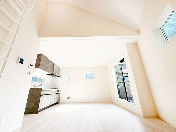 【リビング】勾配天井が生み出す開放感あふれるLDK。3方向から柔らかな光が届き、どの時間帯も明るく快適に。省スペース設計ながら、空間の広がりをしっかり感じられる住まいです。