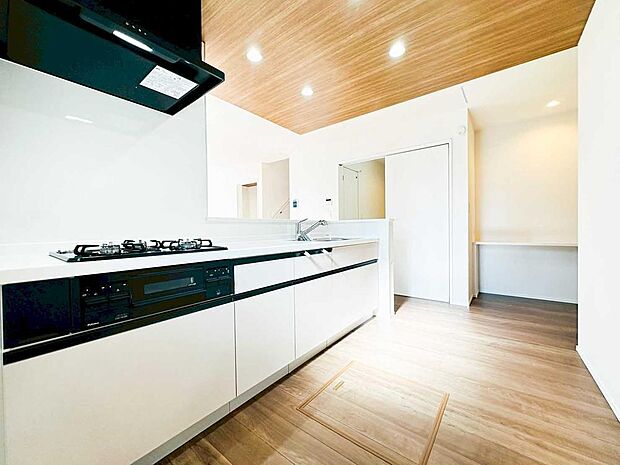 【キッチン】白基調のキッチンに木目天井が映える洗練LDK。広さと明るさを感じる空間で、毎日の料理や団らんが心地よく。