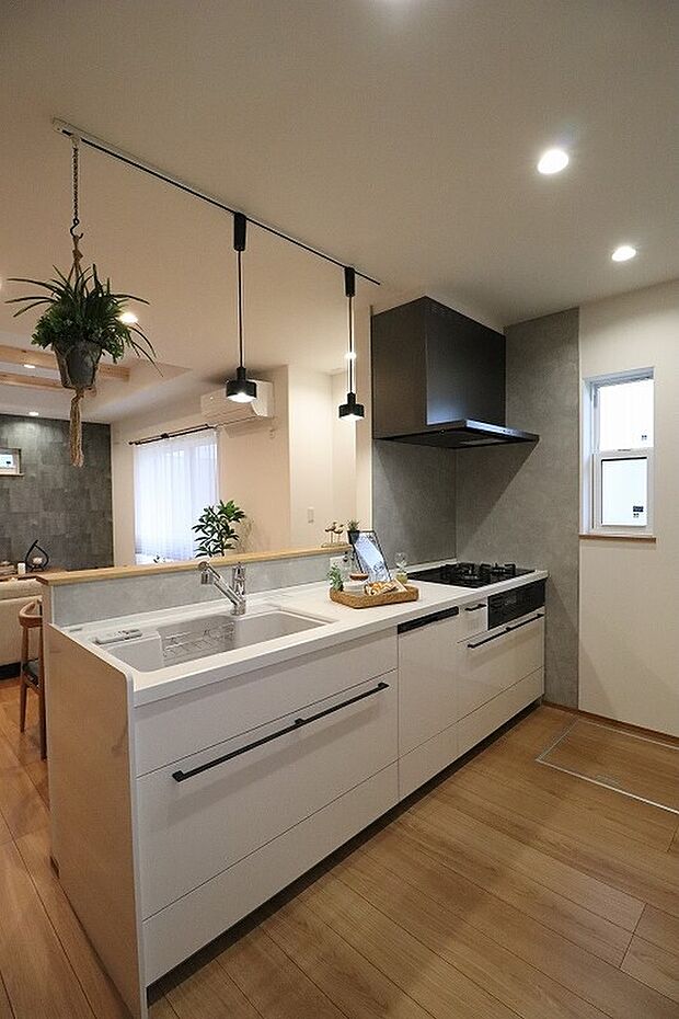 【料理中も家族とつながる開放的な設計】手元が隠れる腰壁付きで、リビング側からはスッキリ見えます。食洗機や広々シンクなど、毎日の家事を支える機能も充実しています。