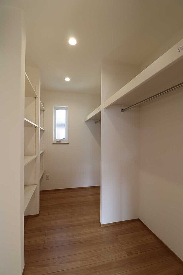 【ハンガーパイプと可動棚を備えた大容量クローゼット】主寝室から繋がる広々とした収納スペース 。衣類だけでなく、季節物や小物もスッキリ整理でき、お部屋を広く保てます。