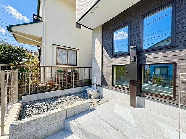 【現地外観写真】モダンな外観が印象的な住まいです。陽光が降り注ぐアプローチは、家族の笑顔を明るく照らします。屋外シンクはガーデニングや外遊びに便利で、子育て世代に嬉しいポイントです。