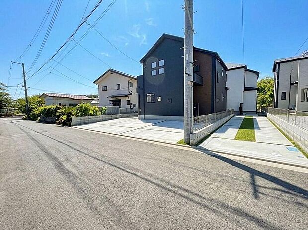 【前面道路含む現地写真】青空に映えるモダンな外観デザインが目を引く住まいです。広々とした駐車スペースは、複数台の車を停められ、毎日の送り迎えや来客時にも便利です。