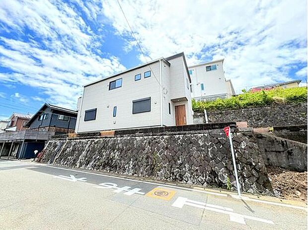 【前面道路含む現地写真】前面道路は6ｍ以上のゆとりある幅員を確保しています。開放感あふれる角地に立地し、陽当たり・通風ともに良好な恵まれた住環境を実現した一邸です。