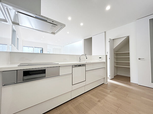 【キッチン　施工例写真】リクシル　システムキッチン「ES」【キレイシンク】
シンク底面がフラットで排水口の見えないスッキリデザイン人造大理石製のシンク。
【タッチレス水栓】
吐水も止水も手をかざすだけなので省エネ効果が期待できます。
また、食器洗い乾燥機、熱のこもりにくいIHコンロ、お手入れのしやすい目地のないフラットなキッチンパネル採用するなど、毎日の家事を快適に行えるように厳選したシステムキッチンです。