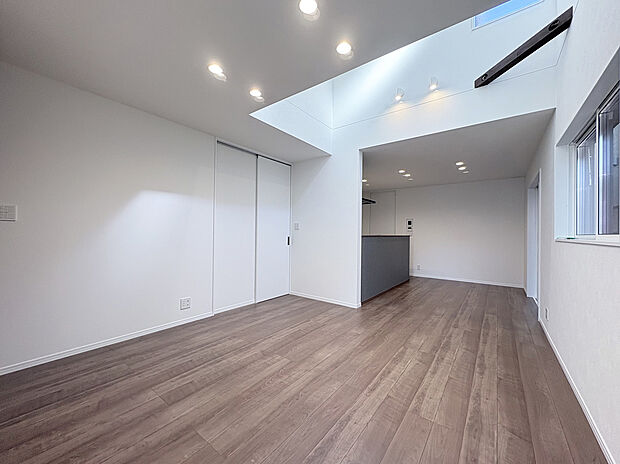 【リビング　A号棟現地写真】■空気を汚さず、ふく射熱で足元からポカポカと暖まる床暖房付き。
■LDK部分には、光をいれるための独立した吹抜けにより開放感もございます。