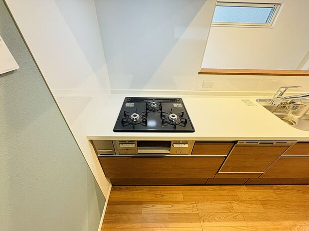 【3口コンロ Panasonic製システムキッチン】TAKI HOUSEの家は、玄関から一歩足を踏み入れると天然木複合フローリングの心地よさとぬくもりが伝わります。
その感触はもちろん、視覚的な木目のやわらかさや自然の濃淡、香りも、住まう人の心をなごませてくれます。
年月を経る中で、太陽光、照明などの光や、熱の影響によって濃度が増したり薄くなったり、様々に変化する天然銘木。同じ部屋に置かれる家具などの経年変化と同調して、程よいバランスを保ちます。一緒に暮らすほどに、味わい深く変化していく一枚一枚違う木目の表情を楽しむ事ができます。