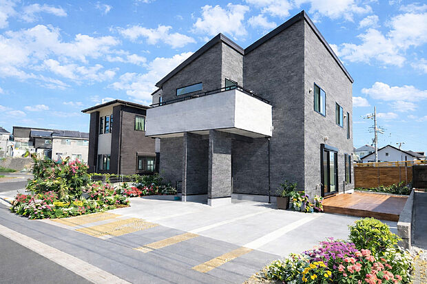 【外観(施工例)】直線美が映えるモダンフォルム、広々駐車スペースと明るい大開口の家。