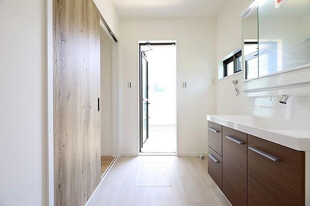 【洗面脱衣室※現地写真】「洗う→干す」が最短！ 洗面脱衣室から、勝手口を通ってそのままお庭へ直行できます。重い洗濯物を抱えて長い廊下を移動する手間がなく、毎日の家事効率が格段にアップ。