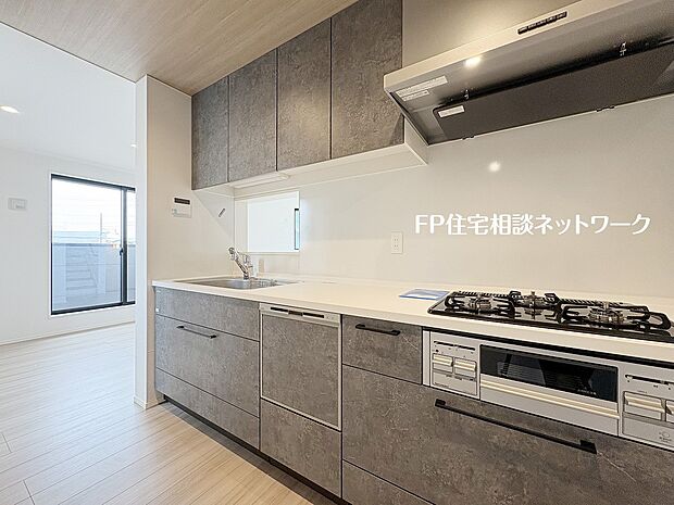 【キッチン】美しさと機能性を両立したシステムキッチン。石目調の扉が空間に高級感を演出。食洗機や三口コンロなど、家事をサポートする充実設備が魅力です。