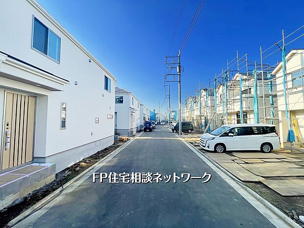 【現地外観写真】建物が続々と完成し、整った街並みが見えてきました。前面道路が広く車のすれ違いも安心。カースペース2台を確保した住まいが並ぶ、落ち着いた住宅エリアです。