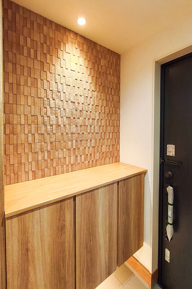 【玄関】アクセントウォールや間接照明が、お客様をお迎えする玄関の表情を豊かに彩ります。(5号棟)