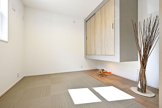 【リビング】肌触りが心地いいテキスタイルをフロアに採用したリビングそばの寛ぎ空間。テキスタイルは、クッション性が高く子ども達の遊び場にもピッタリ。(1号棟)