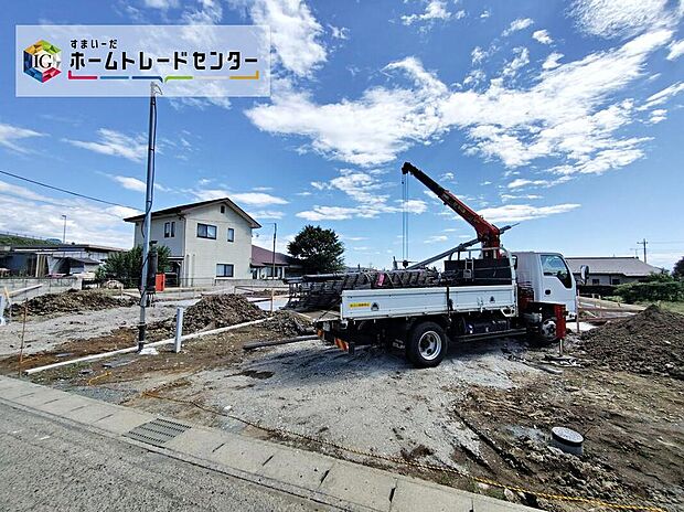 外観写真：造成中の敷地と前面道路の様子が把握できます。道路幅4.7m、敷地面積264.84m2で駐車3台可能。青空が広がる開放的な立地感が魅力で、のびのびとした暮らしに適しています。