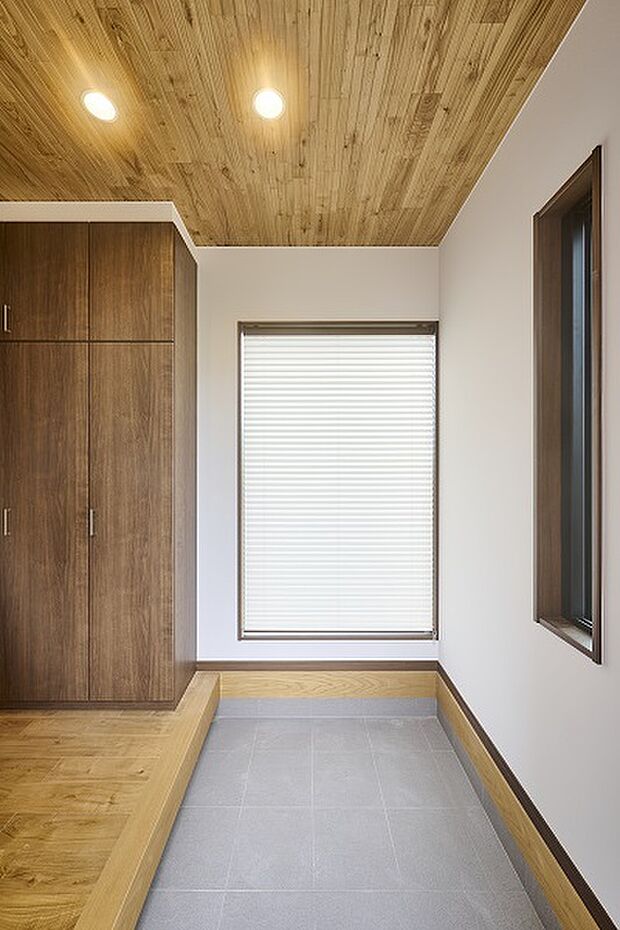 【【レガーレ古賀千鳥3号地】玄関】大きな窓を配置し明るく開放感のある玄関に。壁一面の大きな下足箱があるので玄関回りの収納も困りません。天井にはなめらかな質感と木目が美しい谷川建設オリジナルのメープルを施工、玄関を明るく照らします。