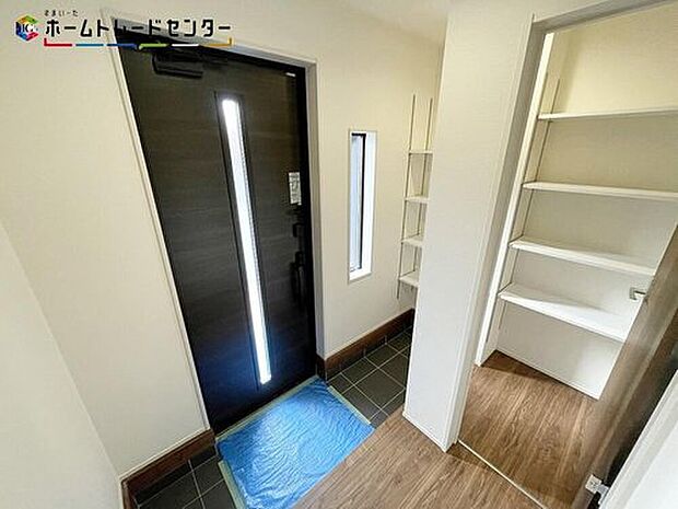 【玄関】１号棟
訪れる人を優しく迎える、スタイリッシュな玄関。開放感のある玄関ホール。温もり感じるフローリング仕様ですので、ご家族やお客様を温かく迎えてくれます。