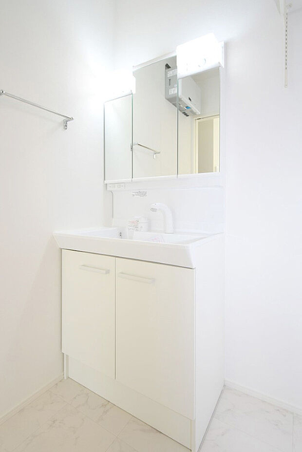 【(1)号棟 洗面】三面鏡の裏は収納スペースとなっており、物が多くなりがちな洗面台まわりをスッキリ保つことができます。※施工事例です。実際の建物とは異なります。