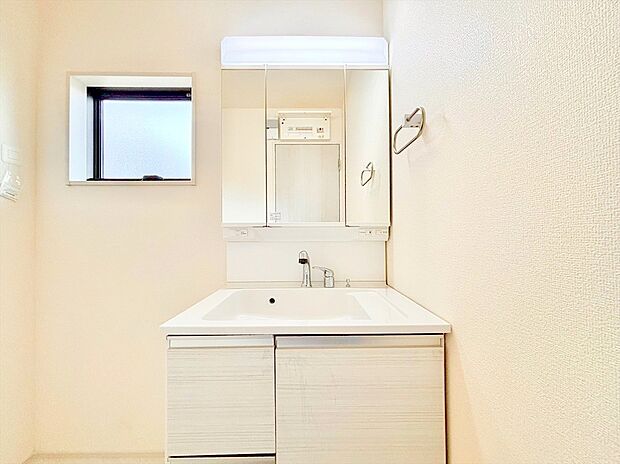 【洗面台】大きな三面鏡がついた洗面化粧台。鏡の裏にも収納があり洗面台がすっきりと片付きます。朝の身支度にも大変便利です。