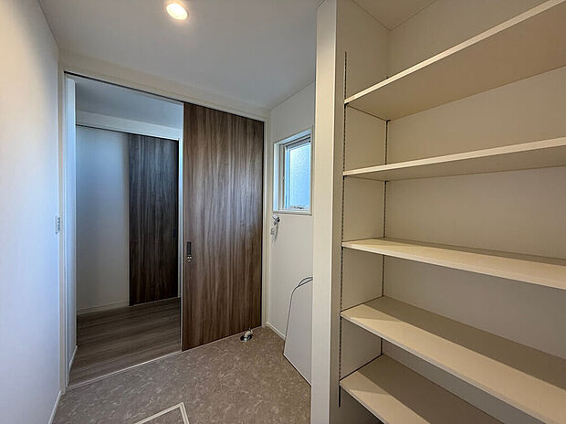 【脱衣室兼ランドリールーム】浴室から収納力抜群の脱衣室兼ランドリールーム、そして、明るいオリジナルの造作洗面台からキッチンにつながる神動線!