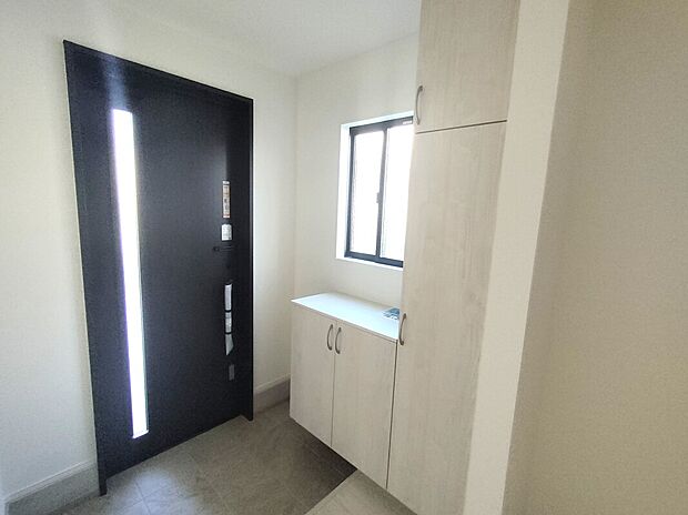 【玄関】ダークカラーの玄関扉と白を基調とした内装が調和した、洗練された印象の玄関スペース。ミラー付き収納や窓からの採光で、明るく機能的な空間に。毎日の出入りが快適にこなせる、暮らしに寄り添う住まいの顔です♪