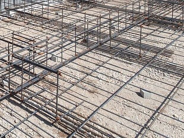 【剛性・耐久性にすぐれた「ベタ基礎」】コンクリートで建物の下一面を支える工法。基礎鉄筋を張り、強度を高めたベタ基礎の耐圧盤を1階の床下全面に施工し、広い耐圧盤の面で建物の荷重を地盤に伝えます。