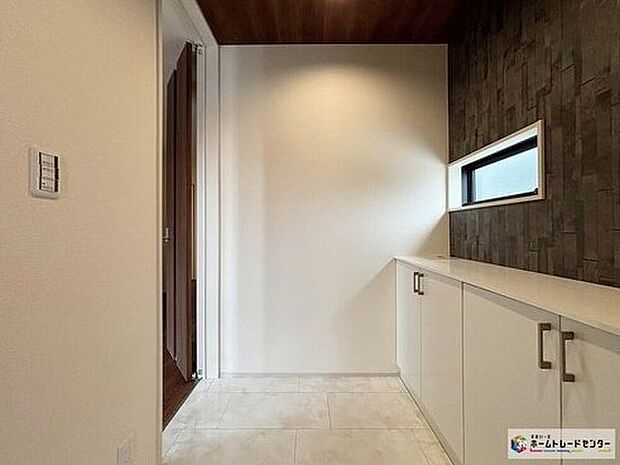 【玄関】大理石調のLタイル仕様が美しい玄関ホール♪落ち着いた色合いのアクセントクロスが印象的なです。横長の窓からやわらかな光が入り、収納も備わっているため玄関まわりをすっきり整えられます♪