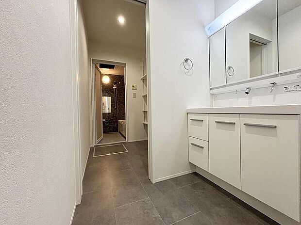 【洗面台・洗面所】【１号棟】ゆとりの洗面スペースで朝の身支度も快適スムーズに。浴室と洗面の間に棚付き収納有りで便利です。