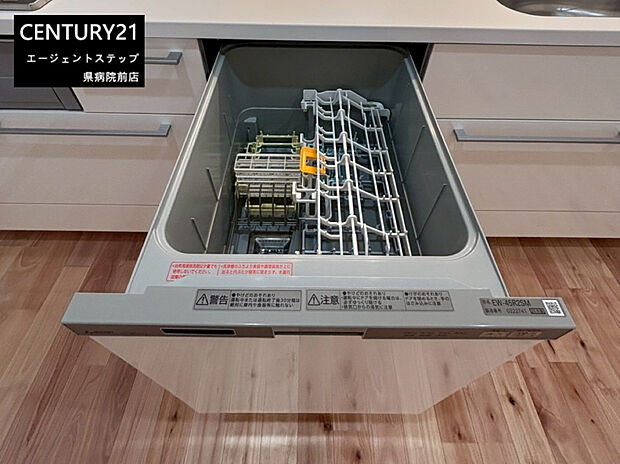 【食器洗い乾燥機】キッチンに食器洗い乾燥機が設置されています。収納スペースも十分で整理しやすい設計です。木目調の床材が空間に温かみを与えています。引き出し式の食洗機で使い勝手が考慮されています。