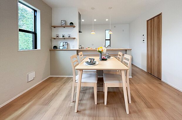 柔らかな光が差し込むダイニング。ペンダントライトが優しく食卓を照らします。対面キッチンなので家族との会話も弾みます。飾り棚には季節の花や写真を添えて、ご夫婦で空間づくりを楽しめます。(1号棟)