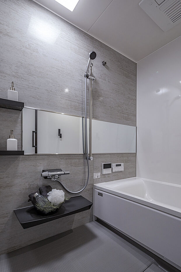 【浴室】無駄のないデザインで仕上げられた浴室は、落ち着いた色合いと明るいバスタブのコントラストが魅力。壁面の素材感が空間に深みを与え、静かで心地よいバスタイムを演出します。設備も扱いやすくまとめられ、家族の誰もが快適に使える機能性と清潔感を兼ね備えた仕上がりです。