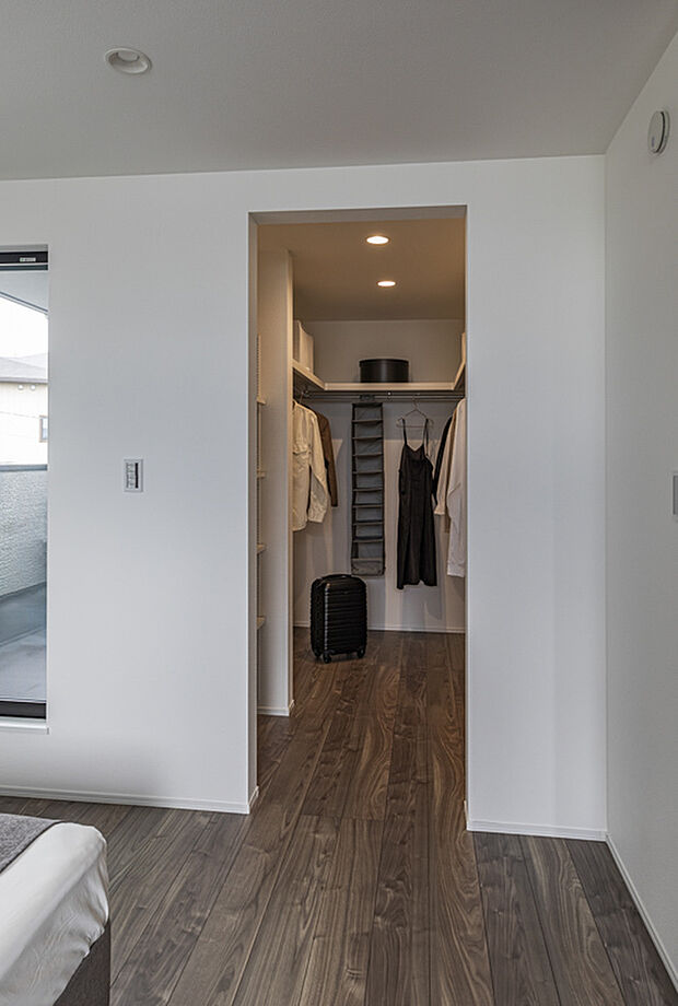 【ウォークインクローゼット】寝室と隣接したWICは「必要なものがすぐ手に届く」理想的な動線で、身支度の時間を大幅に短縮してくれます。収納エリアが独立していることで寝室の美しさを保ちやすく、散らかりにくい点も大きなメリット。奥行きのある空間には衣類がたっぷり収納でき、季節ごとに整えやすい設計です。機能性と美しさが両立したWICが、日常の快適さと暮らしの質を一段上へ導きます。