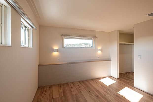 【採光と落ち着きを両立した心地よい主寝室】横長窓から自然光が入り、柔らかく落ち着いた雰囲気の主寝室。ウォークインクローゼットも併設しており、すっきり暮らせる収納力の高い空間です。夜の照明も優しい明るさです。