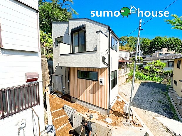 ホワイトと木目調を組み合わせた、スタイリッシュな外観デザイン。第一種低層住居専用地域の落ち着いた街並みに調和しながらも、個性が光る佇まいです。駐車スペース1台分も確保し、都市生活を快適に彩ります。