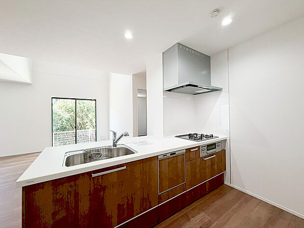 【キッチン】広々としたワークトップと清潔感のある白いカウンターが魅力的なキッチンです。美しい木目調のキャビネットは収納力も抜群で、空間に温かみを添えます。