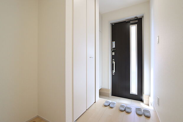 【1号棟玄関】明るい陽射しが差し込む玄関。収納スペースを設けておりますので、ご家族の靴や小物もサッと片づけることができ、スッキリとした印象になります。