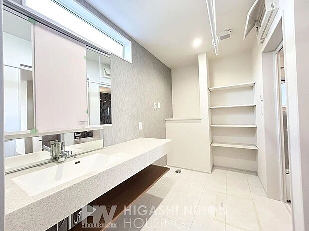 【建物プラン例 (内観写真)】【洗面室施工例】カウンタータイプの洗面台。広さと機能性を兼ね備えた使いやすいデザイン。収納棚も豊富で、家族それぞれの小物類もすっきり収納。天井には室内物干しも設置できる仕様で、洗濯動線もスムーズ。