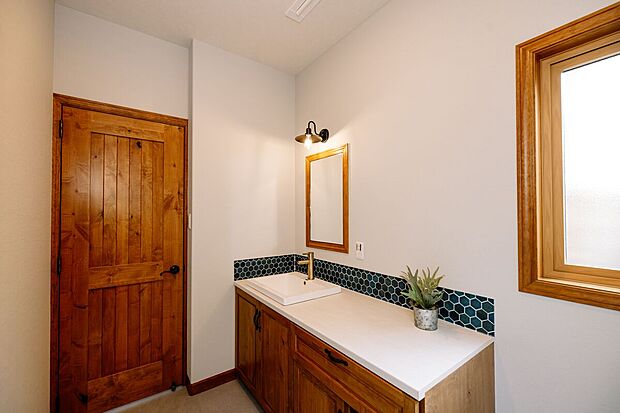 【洗面所】おしゃれなタイルで装飾し、キャビネットなどは自社での手作り唯一無二である、実はキッチンの後ろの棚なども自社でデザインして作っています。