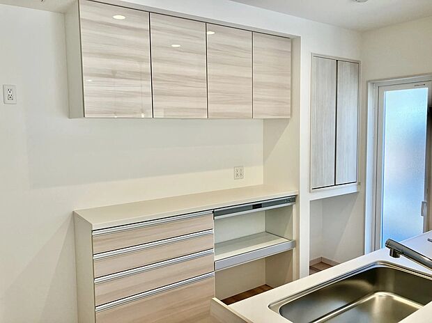 キッチンと融合した味わい深い相柄の風合いのカップボードが、スタイリッシュなキッチンを演出します。食品や飲料のほか、日常使う頻度の少ない調理器具などをたくさんストックできる食品庫も併設。