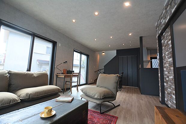 【重厚感と光が調和するLDK参考画像（インダストリアルハウス）】ダークトーンで統一された空間に自然光が差し込むLDK。無骨な素材感と落ち着いた雰囲気が魅力で、ゆったりとした時間を過ごせる居心地の良い空間です。v