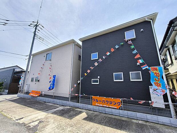 【1・2号棟外観】北側から見た外観写真です。ブラック系とベージュ系の外壁が並び、分譲地全体として落ち着きのある街並みを感じられます。建物まわりにはフェンスを設置し、敷地の境界もすっきりとした印象。