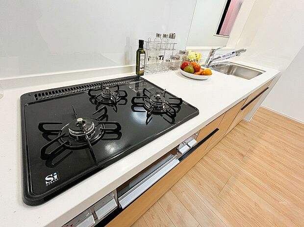 【キッチン】同時調理もスムーズな3口ガスコンロを採用!ワークトップは美しくお手入れしやすいホワイト仕様で、日々の家事効率が上がります。シンクや調味料置き場への動線もスムーズで、快適に料理を楽しめる設計です。