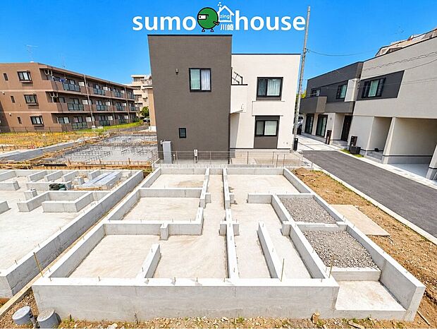 【現地外観写真】建物の基礎工事が進む新築分譲地。周辺には洗練されたデザインの住宅が建ち並び、落ち着いた住環境が広がります。新しい住まいが完成していく期待感とともに、理想の暮らしを思い描けます。