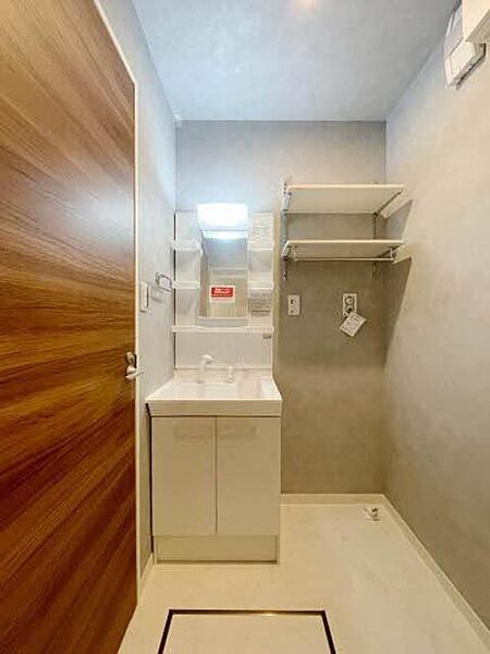 画像9:【洗面所】アッシュグレーの壁紙でスタイリッシュな洗面スペース。洗濯機スペース上部は、洗剤などを置くのに便利な可動棚を配置しました。