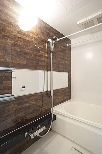 画像9:単調になりがちな浴室にカラー壁面パネルを入れることでアクセントを加え、横長の鏡は空間を広く見せる効果もあります。ユニットバスサイズは1318サイズなのでゆったりとしたバスタイムを楽しむことができます。