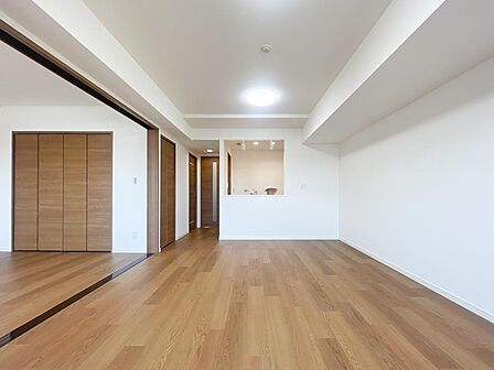木の温もりあふれる広々LDK。対面キッチンと隣接洋室の一体感で開放感たっぷりの家族空間。